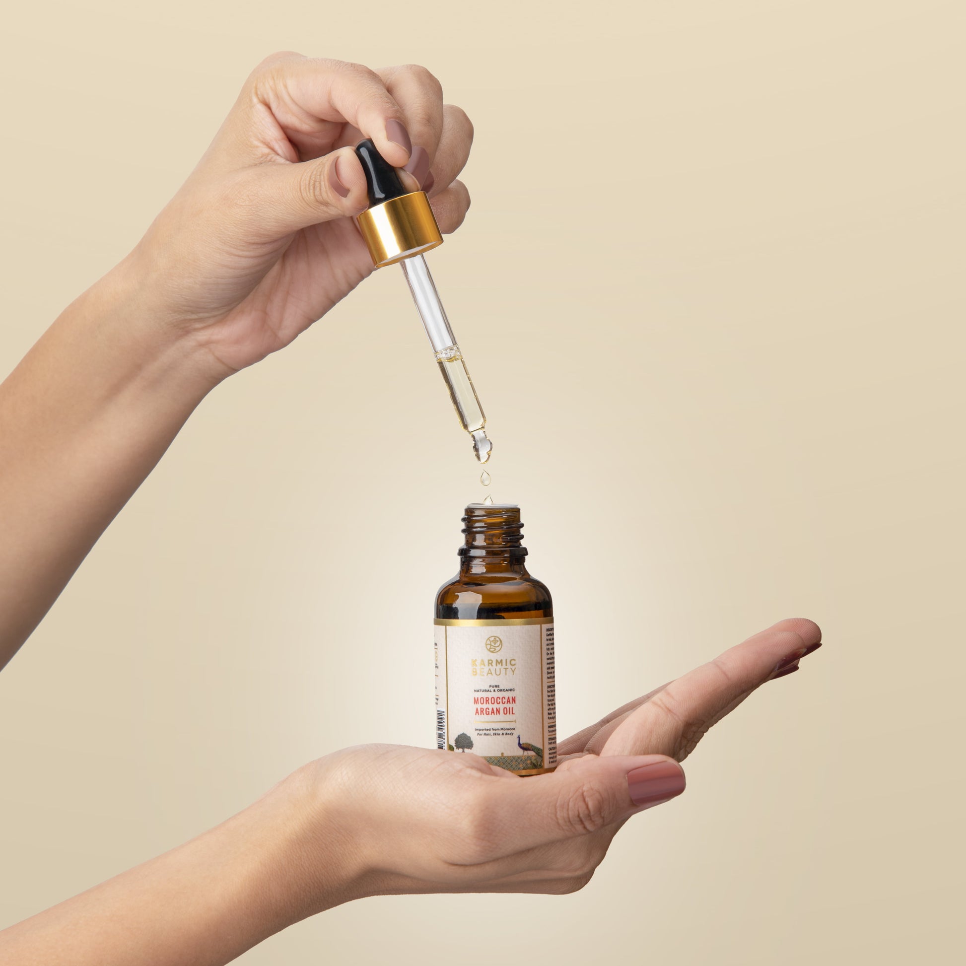 A Girl holding karmic beauty moroccan argan oil in her hand