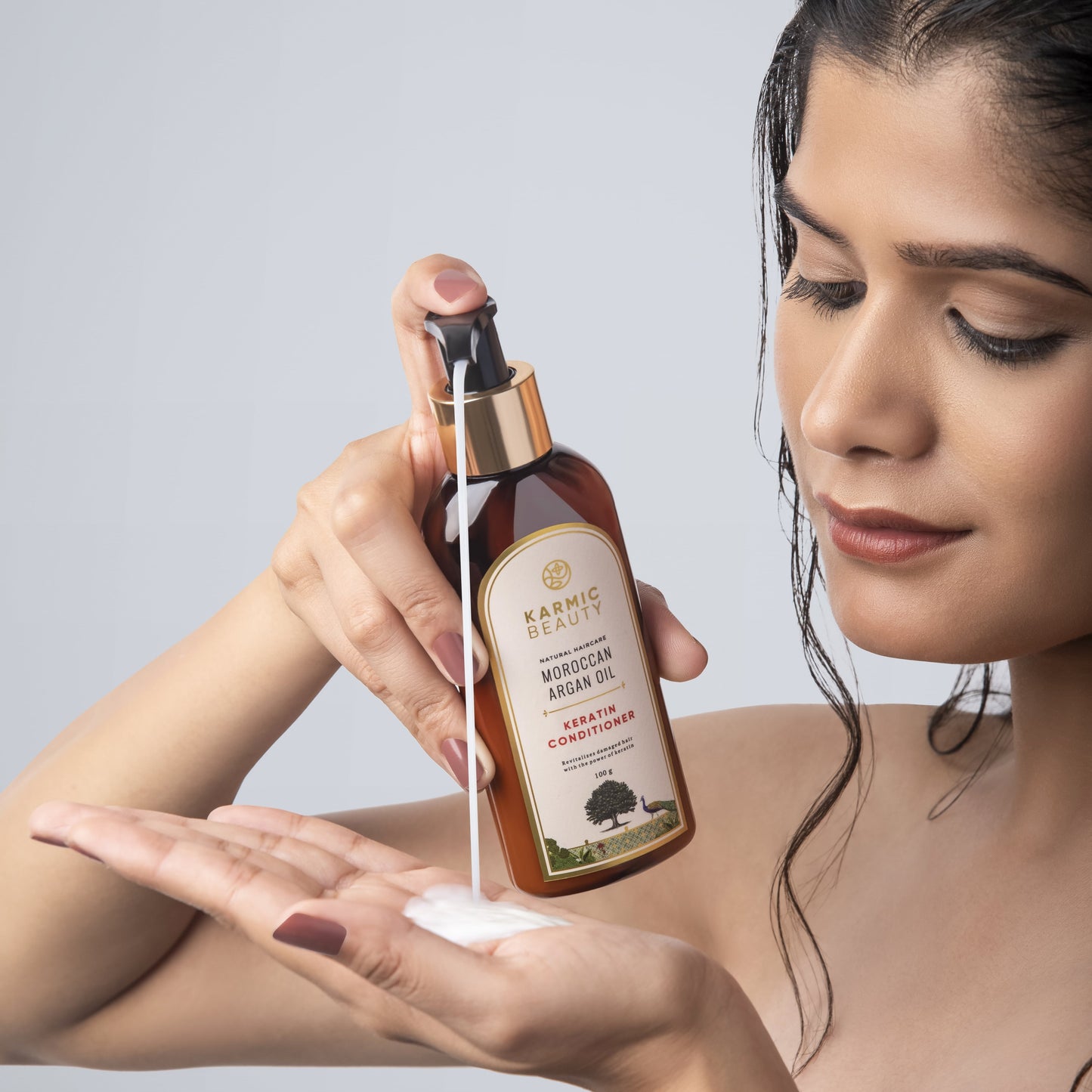 A girl putting Karmic Beauty Moroccan Argan Oil & Keratin Conditioner on her hand