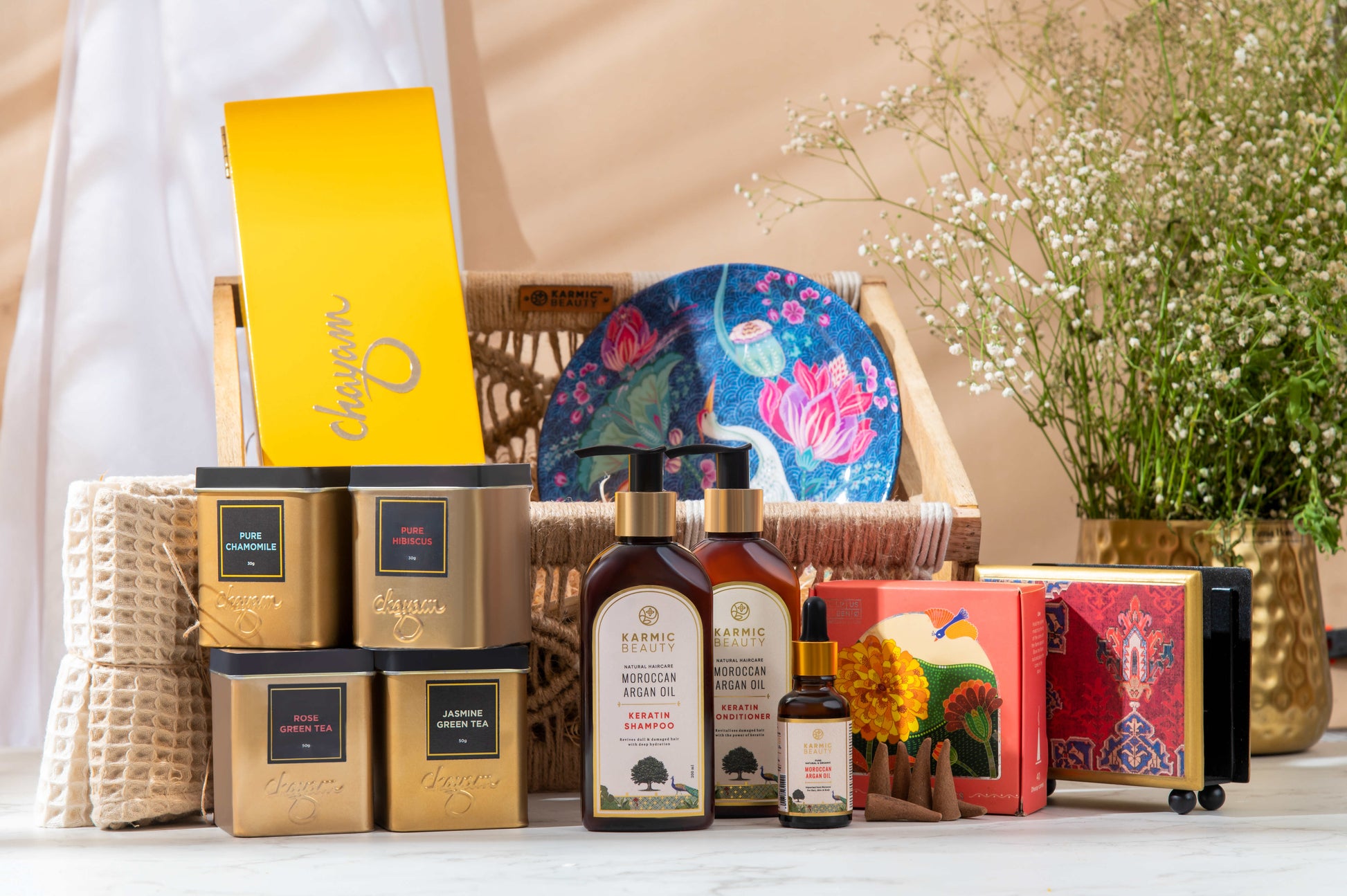 Nourish Nurture Crochet Hamper includes Shampoo, Conditioner, Argan Oil, Napkin Holder, Decorative Wall Plate, Aroma Candle, Tea Chest, Dhoop Cones and Towel Set.