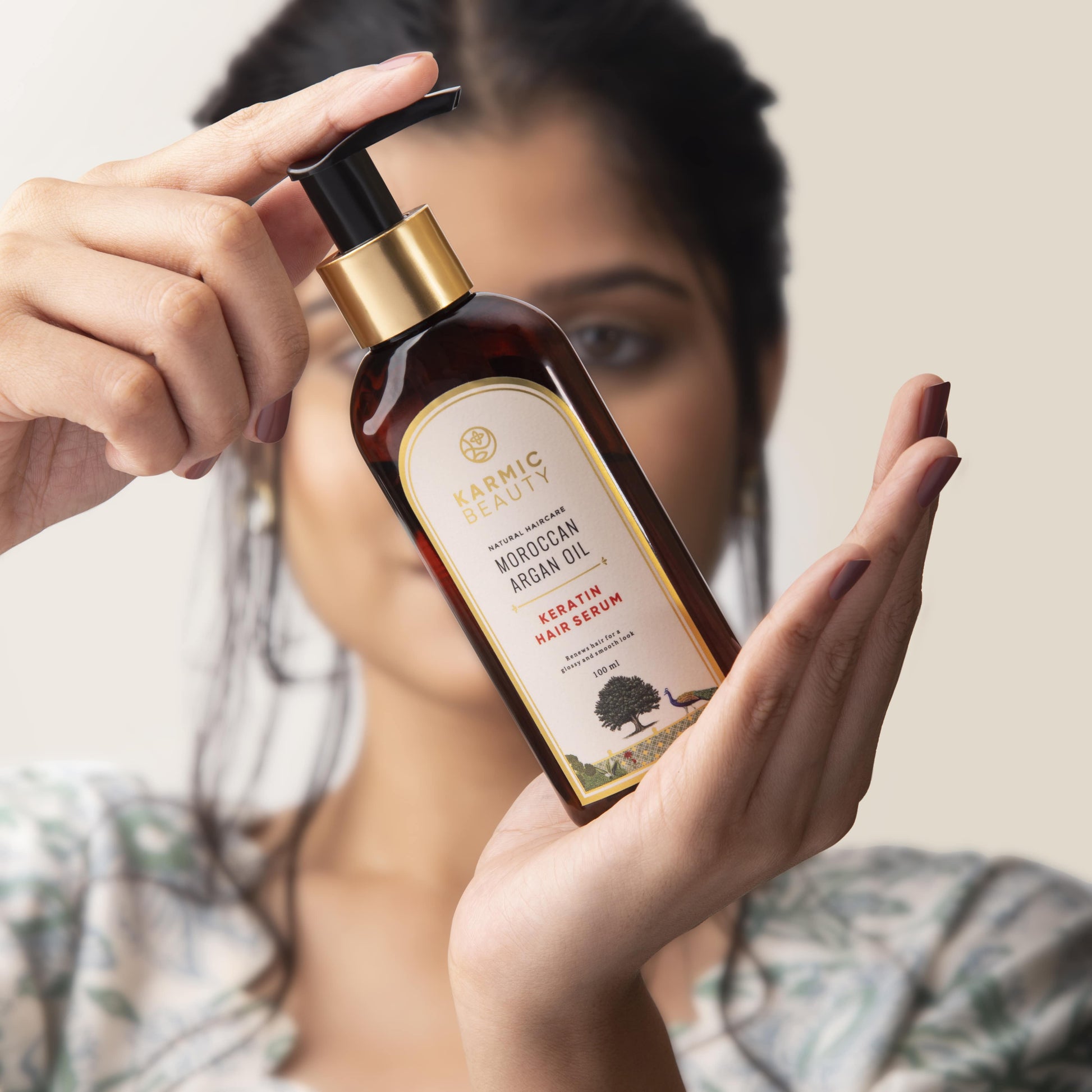 A girl holding Karmic beauty's keratin hair serum.