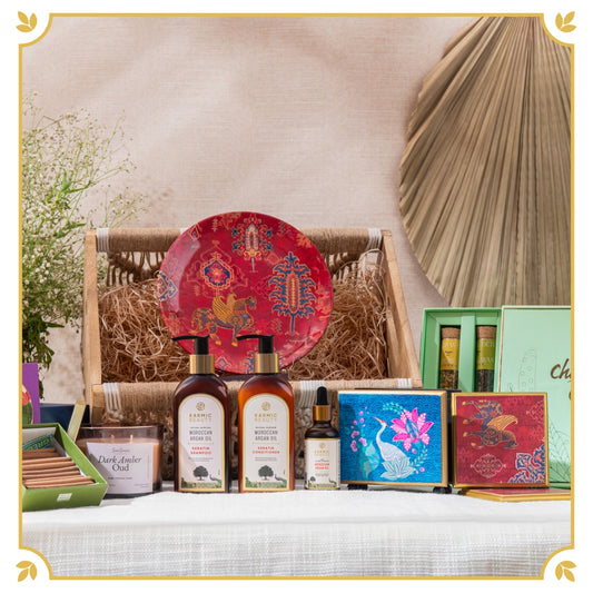 The Grand Serenity Hamper includes Shampoo, Conditioner, Hair Masque, Argan Oil, Decorative wall plate, Tissue Holder, Dhoop Cones, Tea Tubes, Candle in a Crochet Caddy.